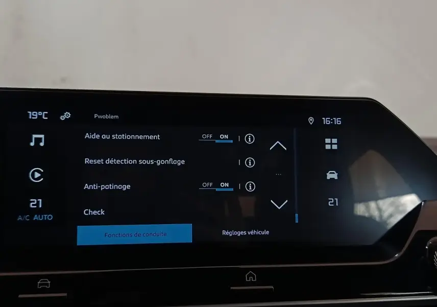 Écran tactile central du tableau de bord de la Citroën C4 X noir, affichant les réglages d’aide au stationnement et d’anti-patinage.