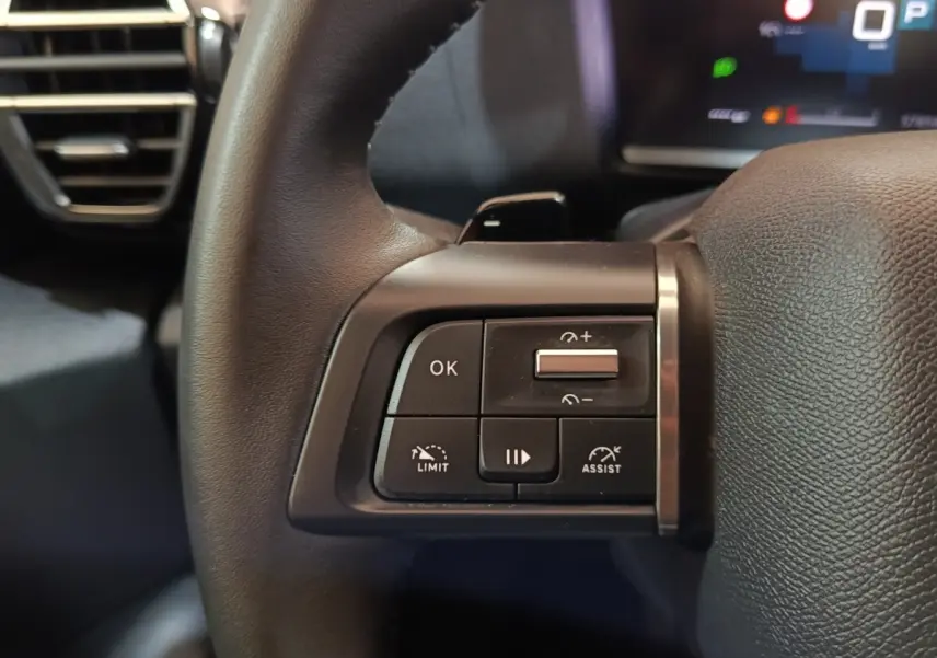Gros plan sur les commandes à gauche du volant cuir noir du Citroën C4 X 2023, avec boutons multifonctions.