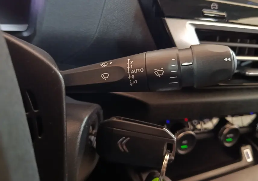 Gros plan sur la commande d’essuie-glace et la clé noire du tableau de bord intérieur d’une Citroën C4 X 2023.
