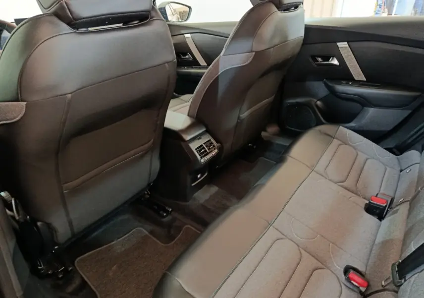 Vue intérieure arrière côté droit de la Citroën C4 X noire, montrant les sièges arrière et la console centrale avec aérateurs.