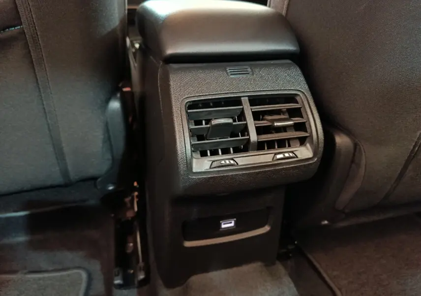 Vue rapprochée des aérateurs arrière et port USB sur la console centrale noire de la Citroën C4 X 2023.