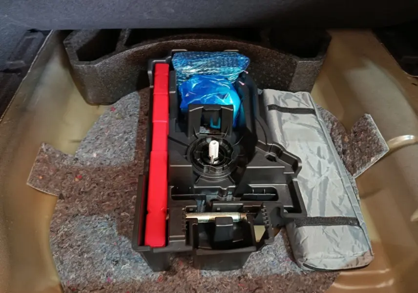 Rangement sous coffre de la Citroën C4 X 2023, contenant outils et accessoires de sécurité.