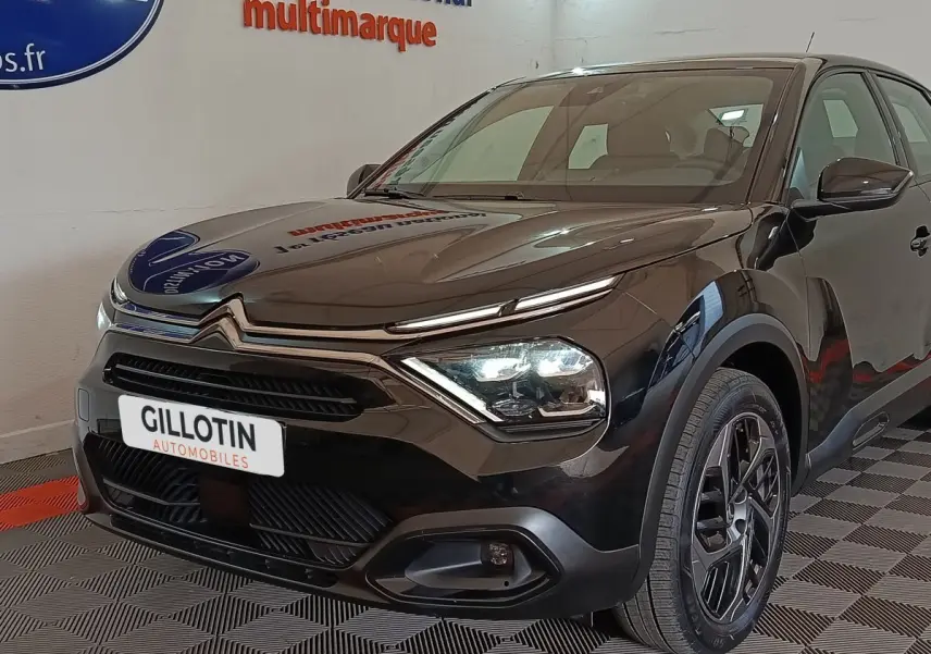 Vue 3/4 avant droite d'une Citroën C4 X noire 2023 avec phares LED et jantes alliage noires.