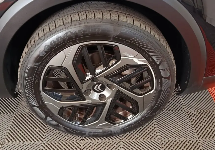 Gros plan sur la roue avant droite noire d’une Citroën C4 X 2023 avec jante alliage et pneu Goodyear.