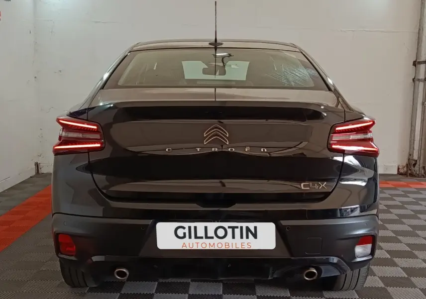 Vue arrière d'une Citroën C4 X noire 2023 avec feux LED distinctifs et double sortie d'échappement visible.
