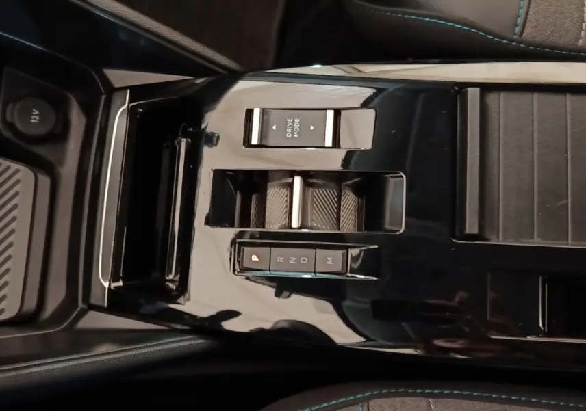 Vue rapprochée de la console centrale noire brillante de la Citroën C4 X avec commandes de boîte auto et bouton Drive Mode.