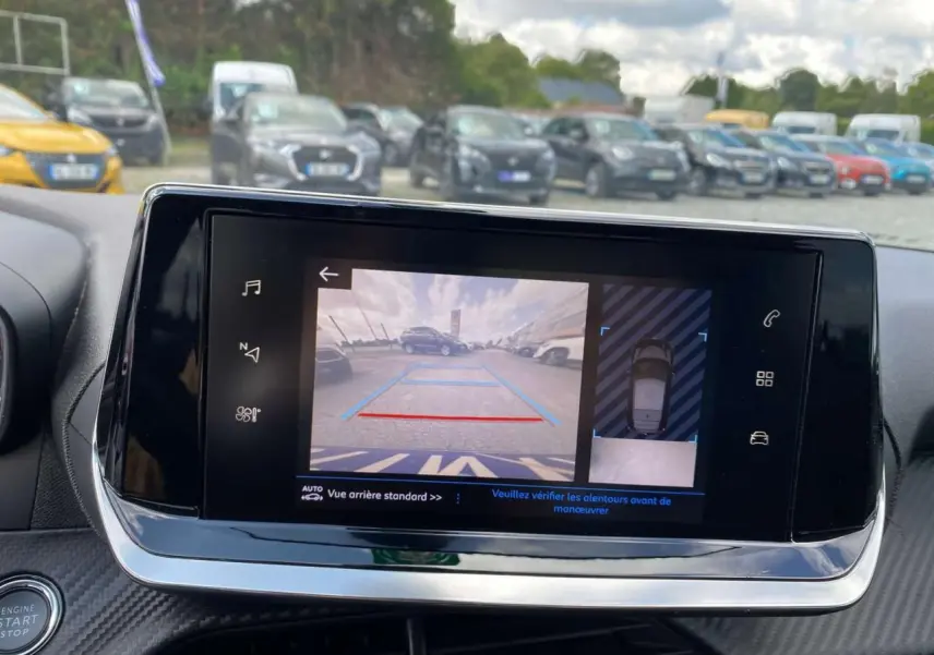 Écran tactile de la Peugeot 208 noire montrant la caméra de recul et la vue 360° du stationnement.