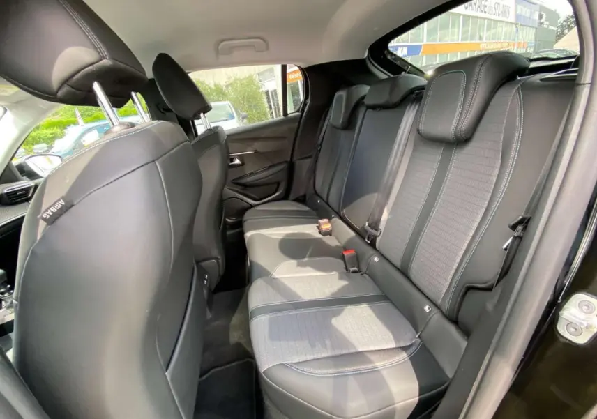 Vue intérieure côté droit des sièges arrière en tissu gris et noir de la Peugeot 208 noire de 2021.