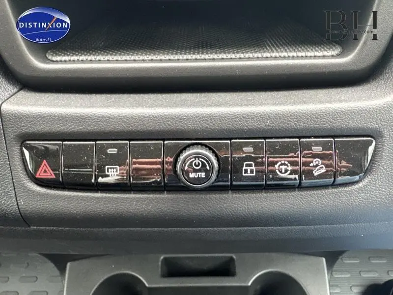 Boutons de commande noirs sur tableau de bord du Fiat Ducato Benne blanc, avec fonction mute au centre.