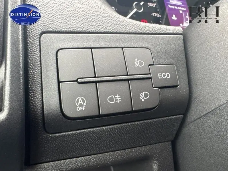 Gros plan sur les commandes d'éclairage et mode ECO du tableau de bord du Fiat Ducato Benne blanc 2023.