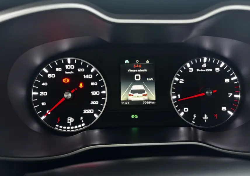 Tableau de bord du MG ZS 2022 avec compte-tours, compteur de vitesse et écran central affichant la voiture vue de dessus.