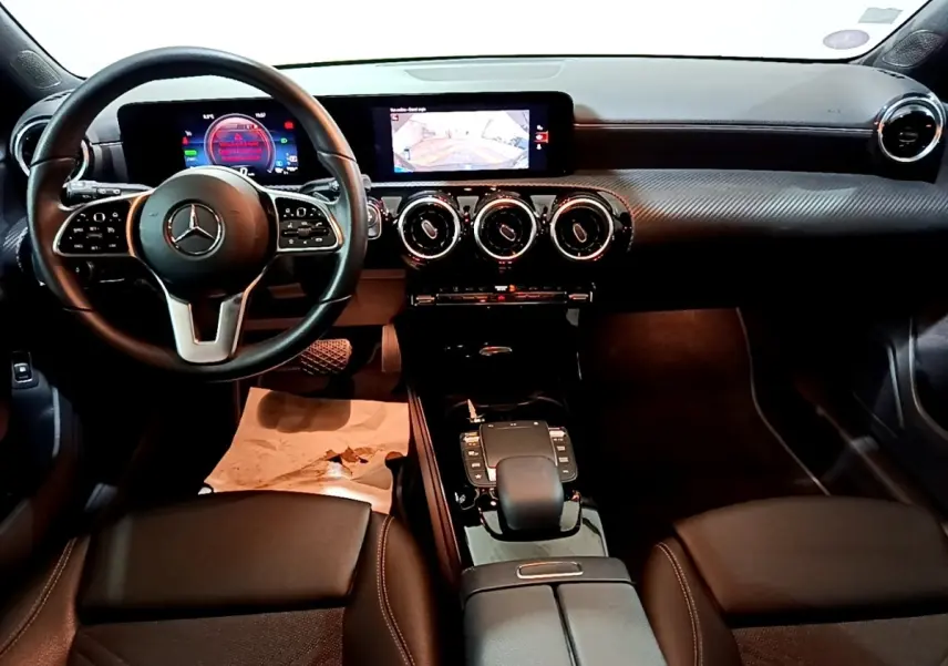 Vue intérieure avant de la Mercedes Classe A 250 e Business Line 2020, tableau de bord noir avec écran tactile et volant cuir multifonctions.