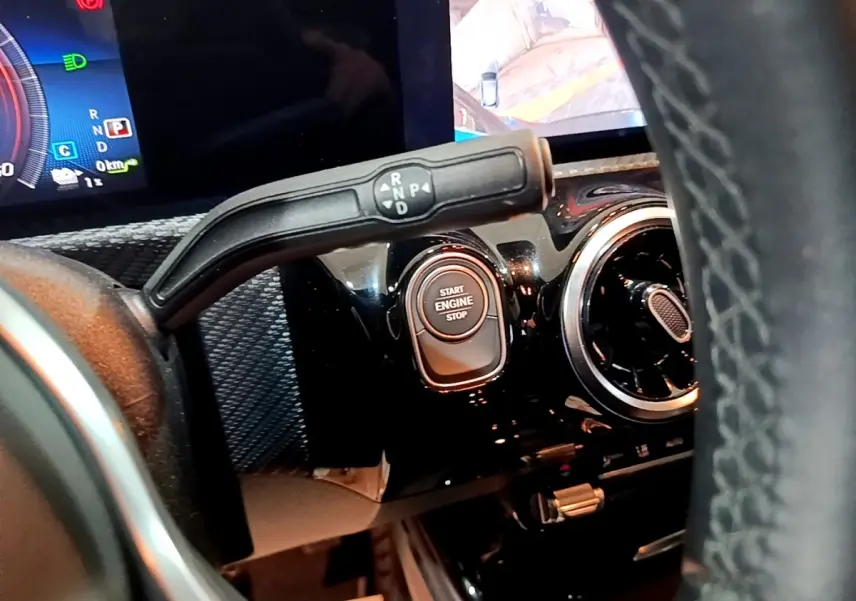 Gros plan intérieur sur la commande de boîte auto et bouton start/stop d'une Mercedes Classe A 250 e Business Line noire.