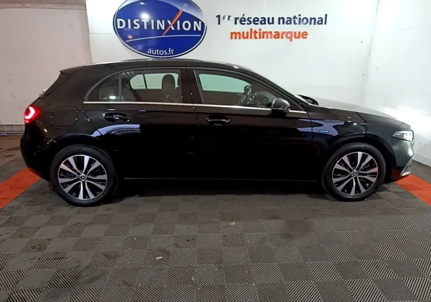 Profil côté gauche d'une Mercedes Classe A noire, hybride rechargeable, avec jantes alliage et feux arrière allumés.