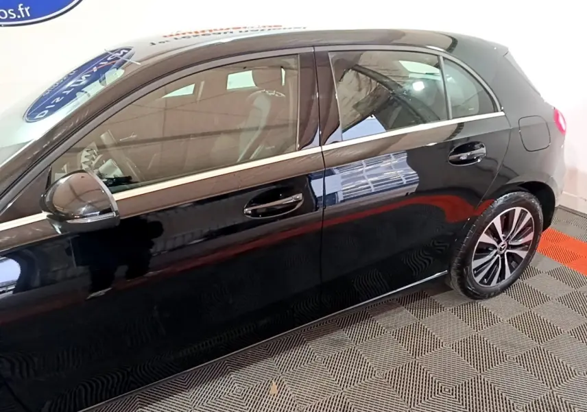 Vue latérale côté gauche d'une Mercedes Classe A noire avec jantes alliage et poignées de porte chromées.