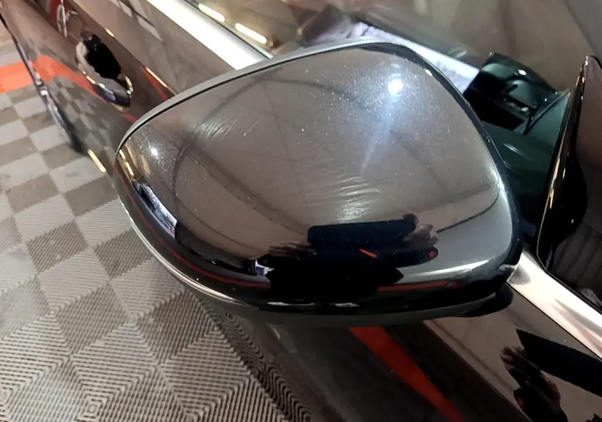 Gros plan sur le rétroviseur côté droit noir brillant d’une Mercedes Classe A 250 e Business Line 2020.