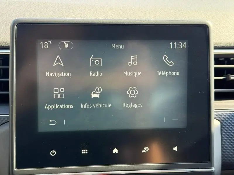 Écran tactile central du Renault Arkana 2025 affichant le menu principal avec navigation, radio, musique et téléphone.