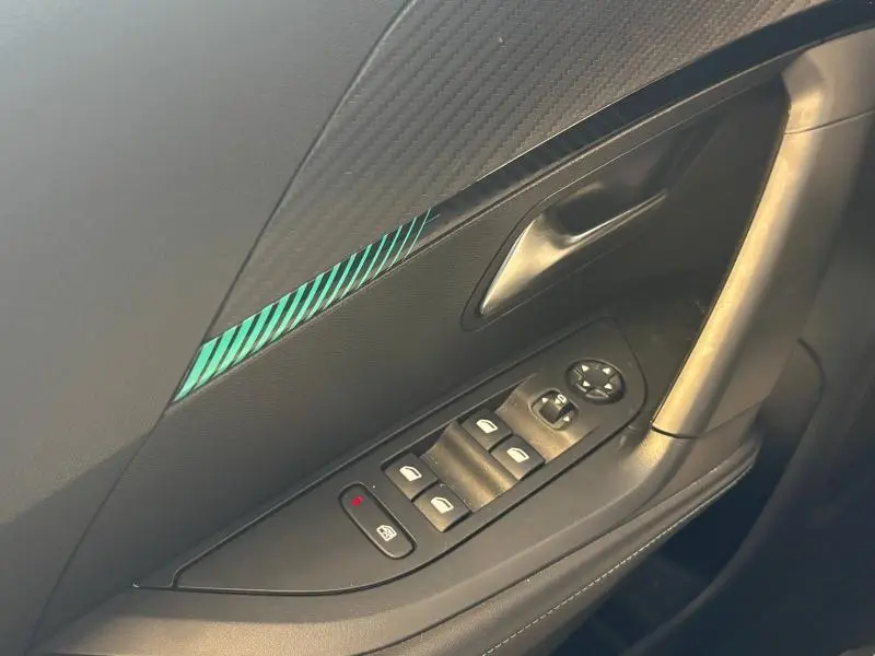 Gros plan sur la porte avant gauche du Peugeot 2008 noir Perla Nera, montrant les commandes électriques des vitres et le décor bleu.