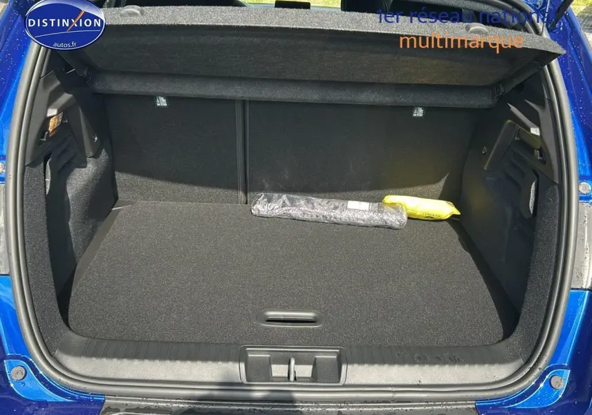 Coffre ouvert du Renault Captur bleu iron 2025, vue arrière montrant l'espace de chargement vide avec cache-bagages.