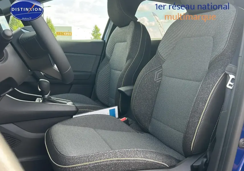 Intérieur du Renault Captur 2025 bleu iron, vue côté droit sur sièges avant en tissu gris avec surpiqûres claires.