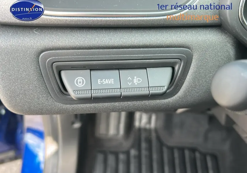Gros plan sur les commandes E-SAVE et réglage des phares dans l'habitacle d'un Renault Captur Bleu Iron 2025.