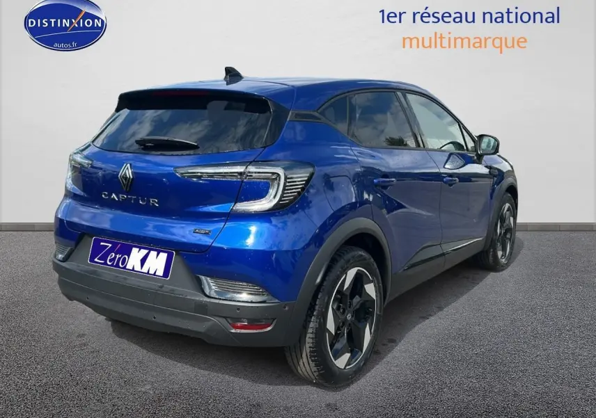 Vue 3/4 arrière droite du Renault Captur bleu iron 2025 avec jantes alu et vitres teintées.