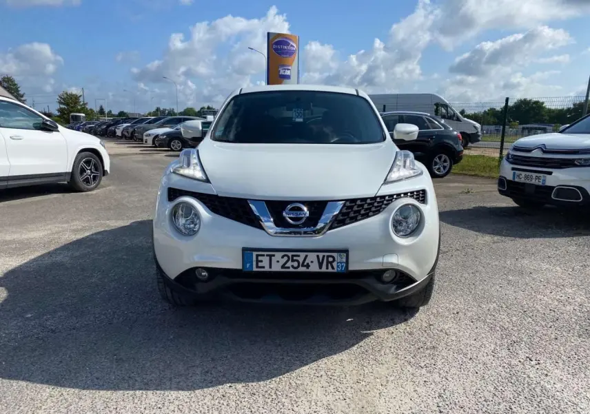 Vue frontale d'un Nissan Juke blanc métallisé 2017 avec phares ronds et calandre chromée.