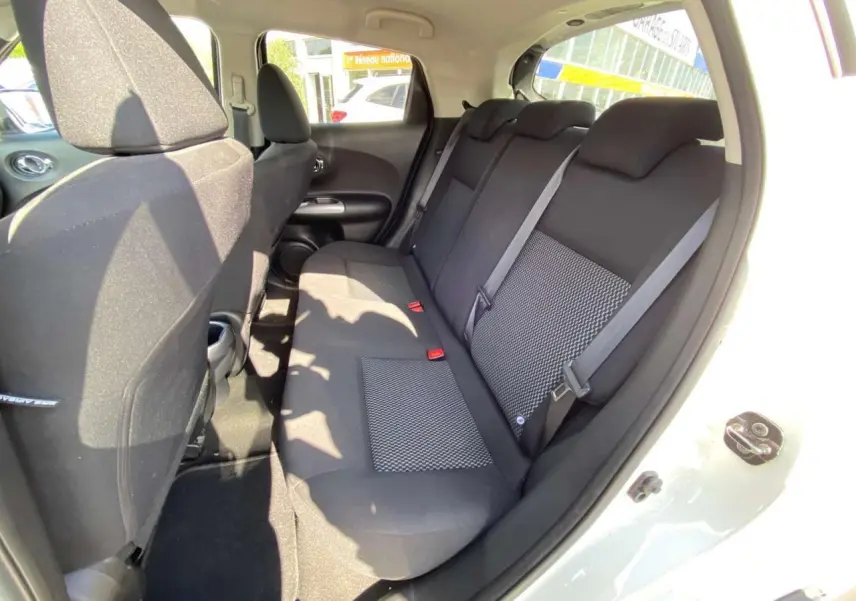 Vue intérieure côté droit sur la banquette arrière noire du Nissan Juke blanc 2017 avec porte ouverte.