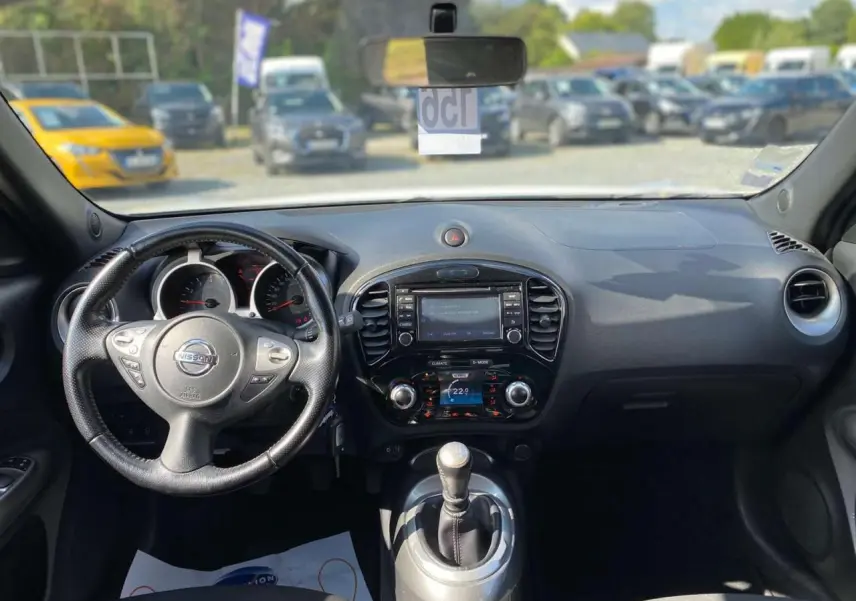 Vue intérieure du tableau de bord et volant du Nissan Juke blanc 2017 avec boîte manuelle et écran central tactile.