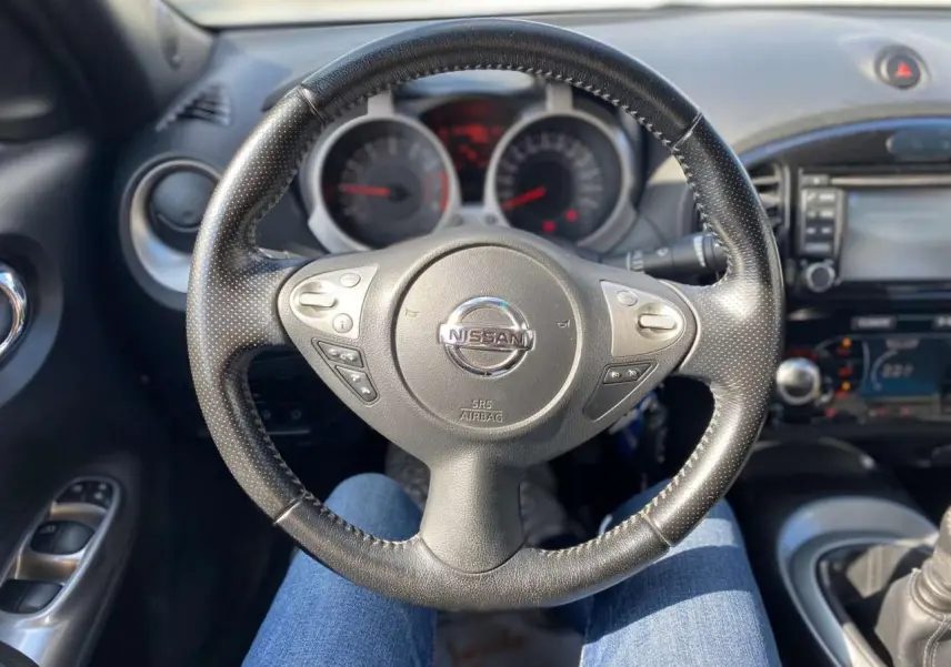 Vue intérieure centrée sur le volant noir perforé du Nissan Juke 2017, avec tableau de bord et commandes visibles.