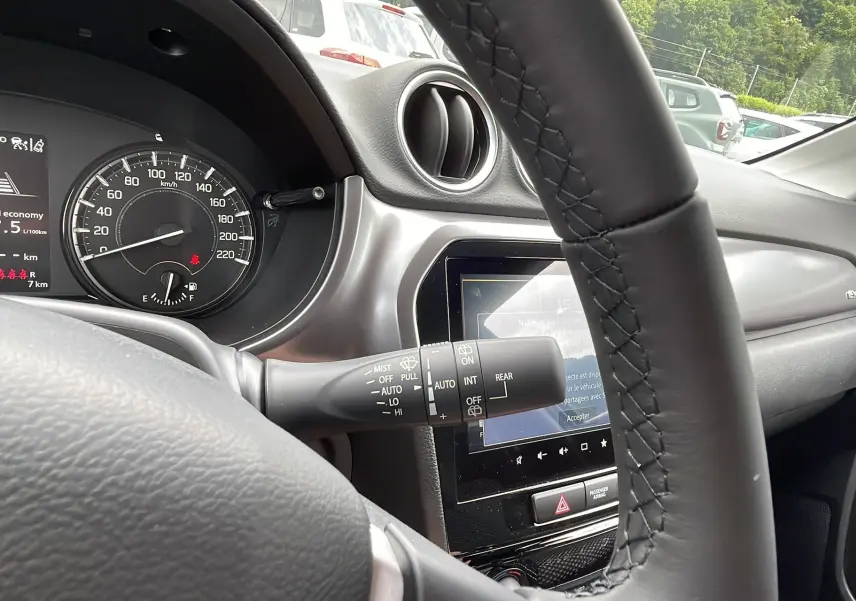 Intérieur du Suzuki Vitara 2025 en silky silver, vue côté conducteur sur le tableau de bord et le volant cuir noir.