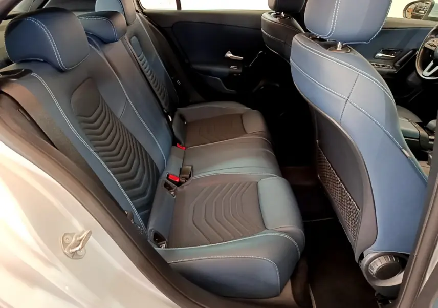 Vue intérieure côté arrière droit de la Mercedes Classe A 180 d Business Line 2020, sièges tissu bleu et noir avec surpiqûres blanches.