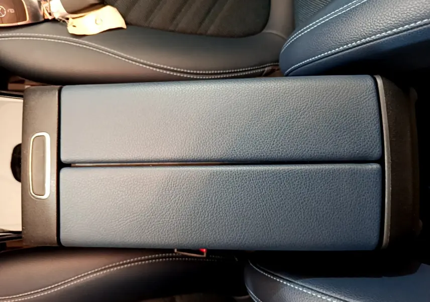 Vue rapprochée de l'accoudoir central en cuir noir avec surpiqûres blanches dans l'habitacle d'une Mercedes Classe A 180 d.