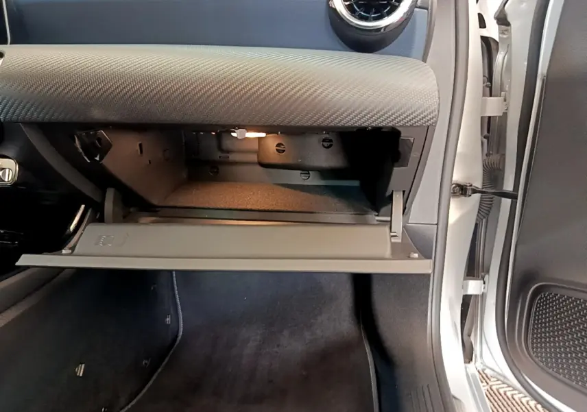 Vue intérieure côté passager montrant la boîte à gants ouverte et le tableau de bord gris clair d'une Mercedes Classe A 180 d 2020.