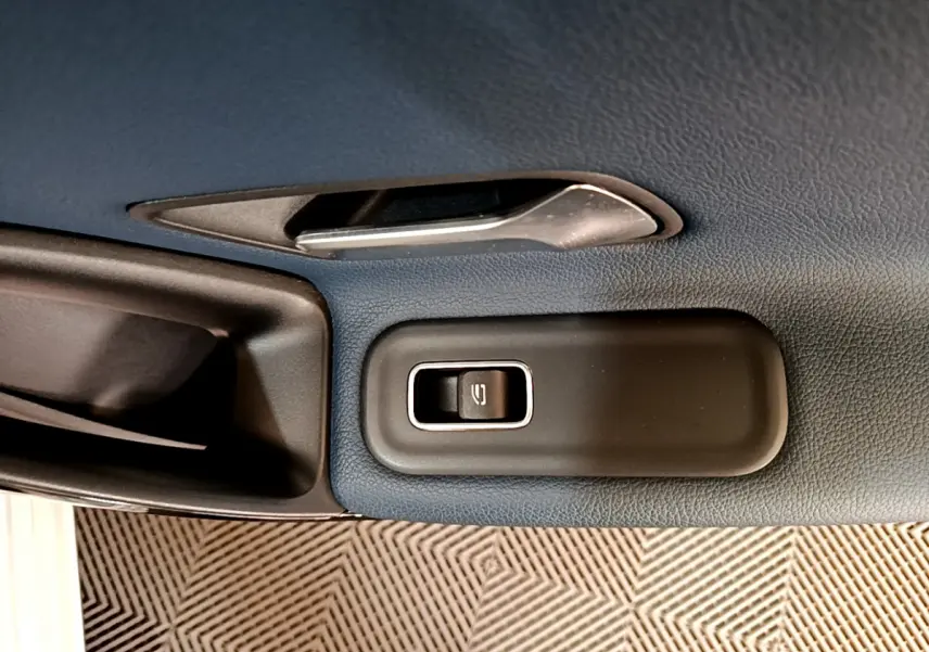 Détail de la commande de lève-vitre sur la porte intérieure côté conducteur d’une Mercedes Classe A gris clair.