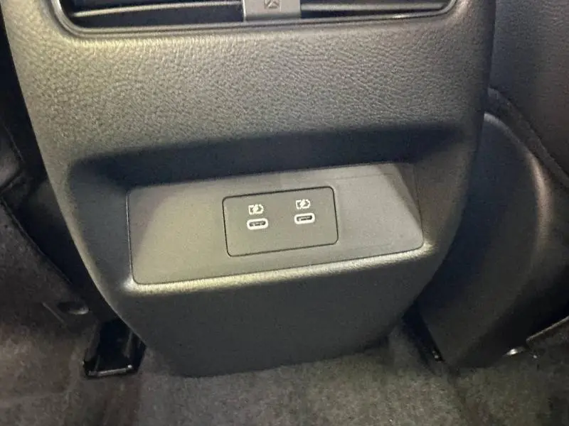 Prise USB double en gros plan sur la console arrière d’un Nissan Qashqai Hybrid e-POWER 2025 noir Kuro métallisé.