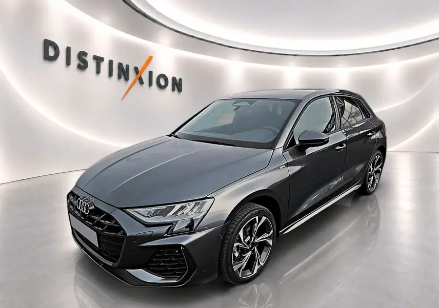Audi A3 Sportback gris Daytona en 3/4 avant droit avec jantes alu et calandre noire distinctive.