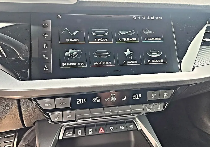 Vue rapprochée de la console centrale de l’Audi A3 Sportback 2026, écran tactile et commandes climatisation visibles.