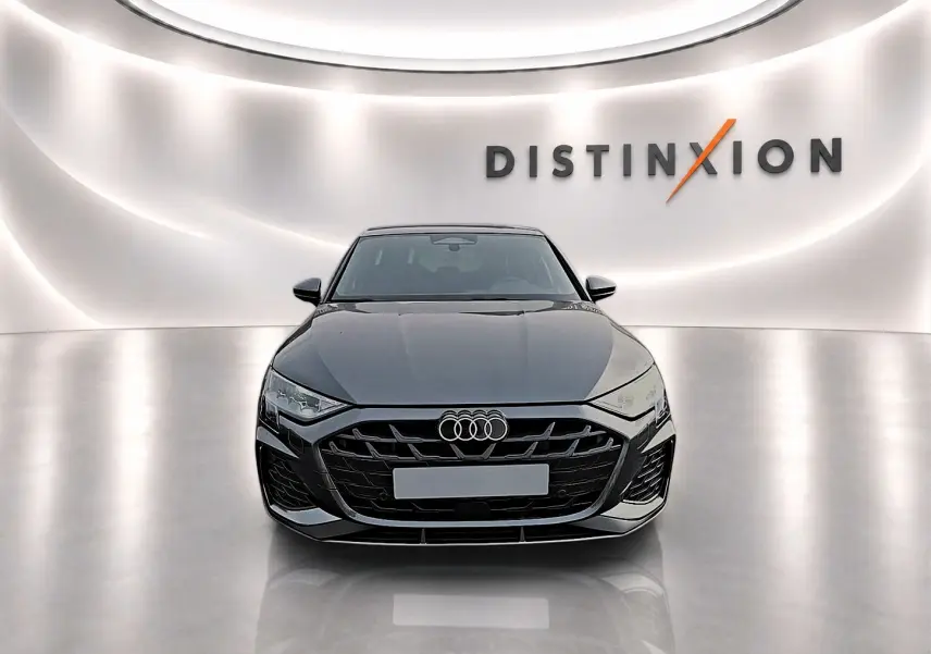 Audi A3 Sportback gris Daytona vue de face dans un studio avec logo Distinxion en arrière-plan.