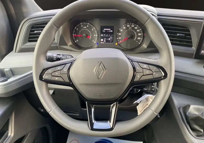 Vue rapprochée du volant gris avec commandes intégrées et tableau de bord du Renault Master 2025.