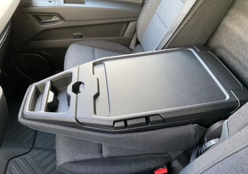 Détail intérieur montrant la banquette passager grise avec bureau mobile et rangements dans un Renault Master 2025.