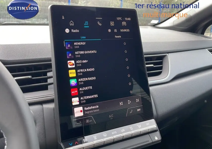 Vue intérieure du tableau de bord du Renault Captur E-Tech gris cassiopée, écran tactile central affichant les radios numériques.