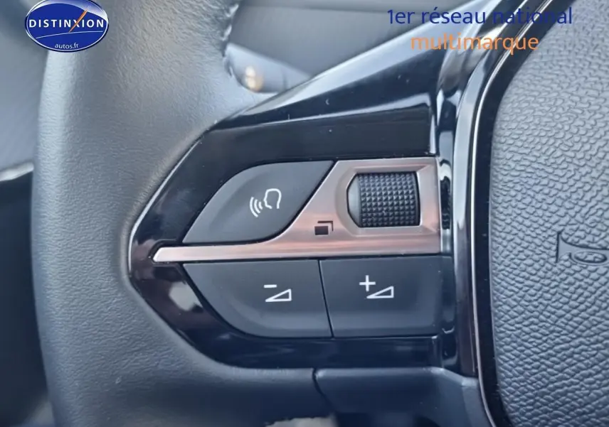 Gros plan sur les commandes audio au volant noir de la Peugeot 208 1.2 100 Allure gris Artense, côté gauche.