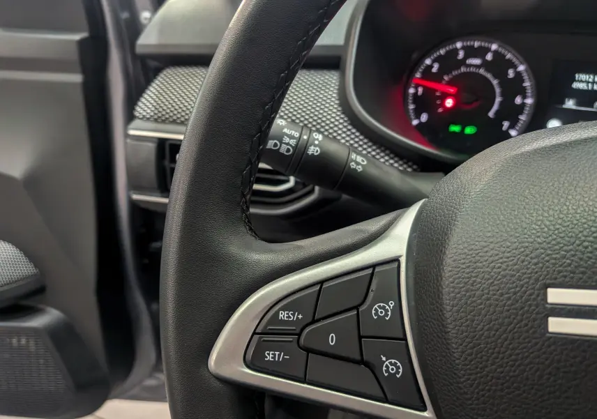 Gros plan sur le volant de la Dacia Sandero TCe 90 CH Journey 2025, montrant les commandes de régulateur de vitesse.