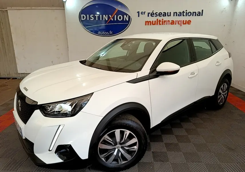 Peugeot 2008 blanc vue 3/4 avant droit dans un showroom avec jantes alliage et feux LED distinctifs.