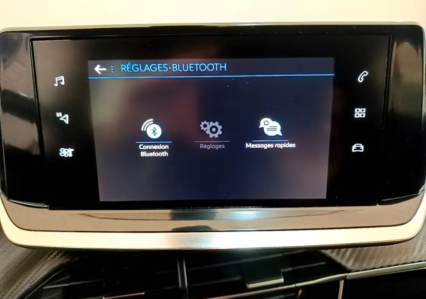 Écran tactile central du tableau de bord du Peugeot 2008 blanc, affichant les réglages Bluetooth.