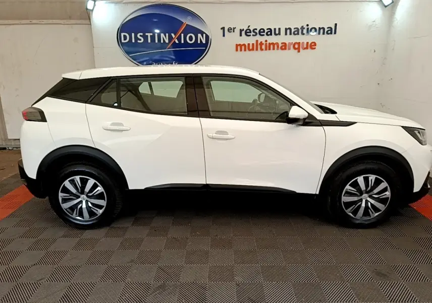 Profil côté gauche du SUV Peugeot 2008 blanc 2021 avec jantes alliage et détails noirs contrastants.