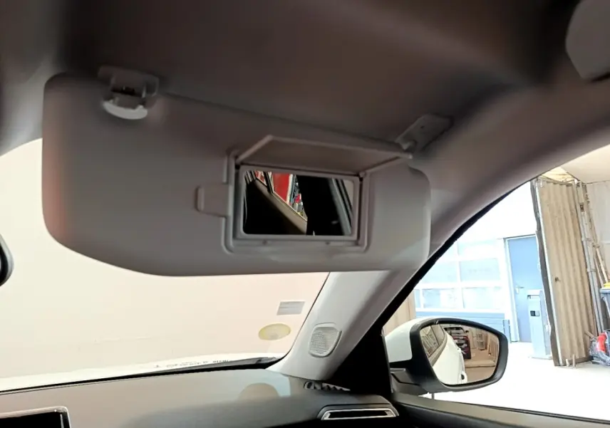 Intérieur du Peugeot 2008 blanc 2021, vue sur pare-soleil avec miroir et rétroviseur côté droit visible.