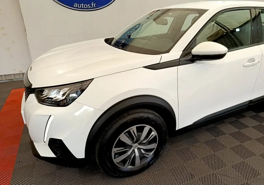 Vue 3/4 avant droit d’un Peugeot 2008 blanc avec phares LED et jantes alliage distinctives.