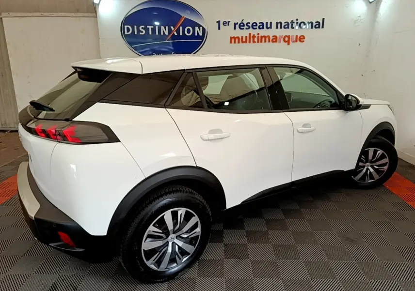 Vue 3/4 arrière droite d’un Peugeot 2008 blanc avec feux arrière LED et jantes alliage en showroom.